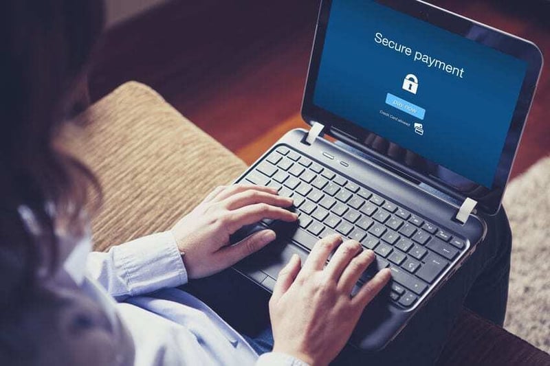 "Secure payment" on the screen. Hands over the keyboard on lapto